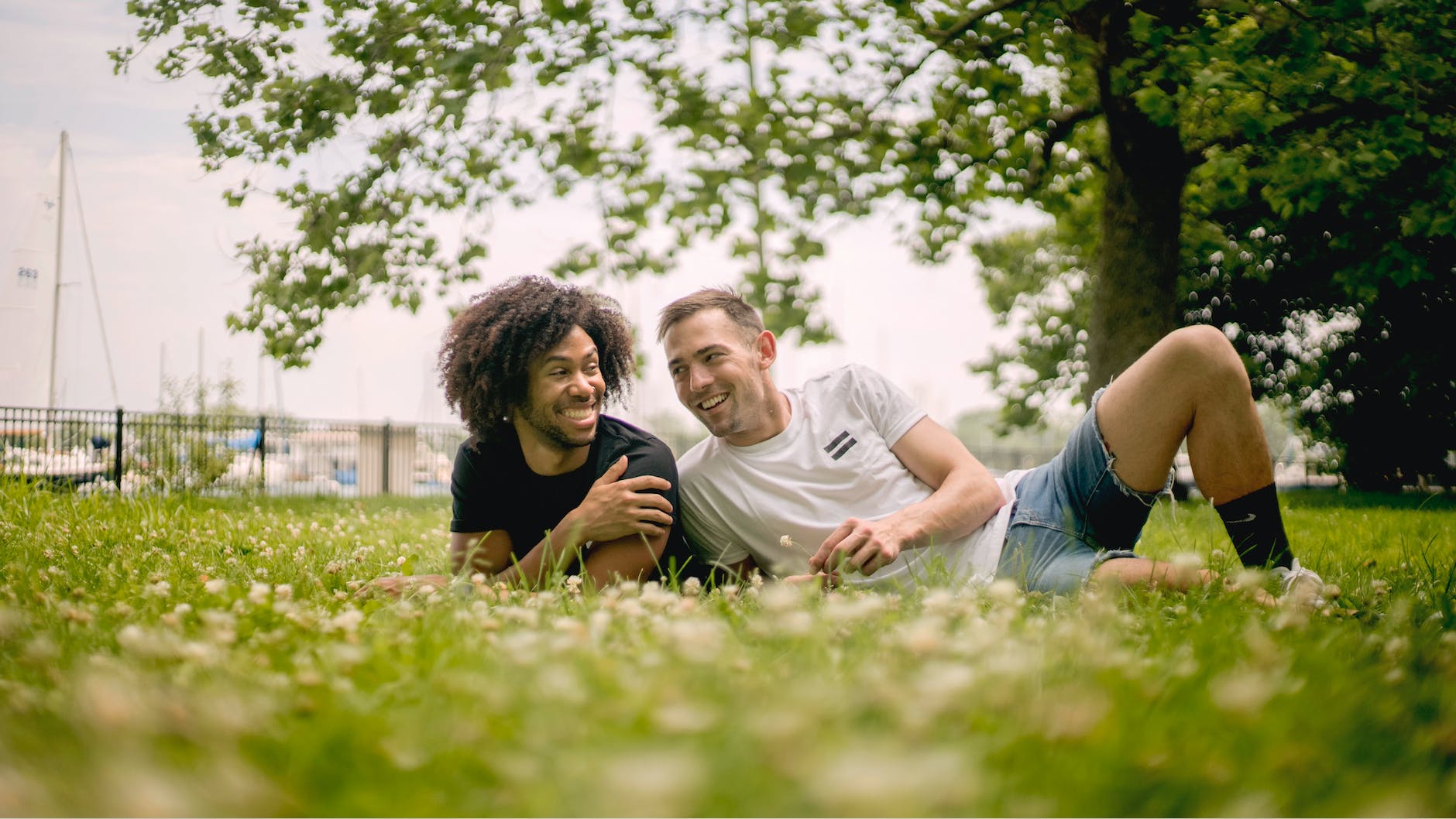 smiling men lying on grass