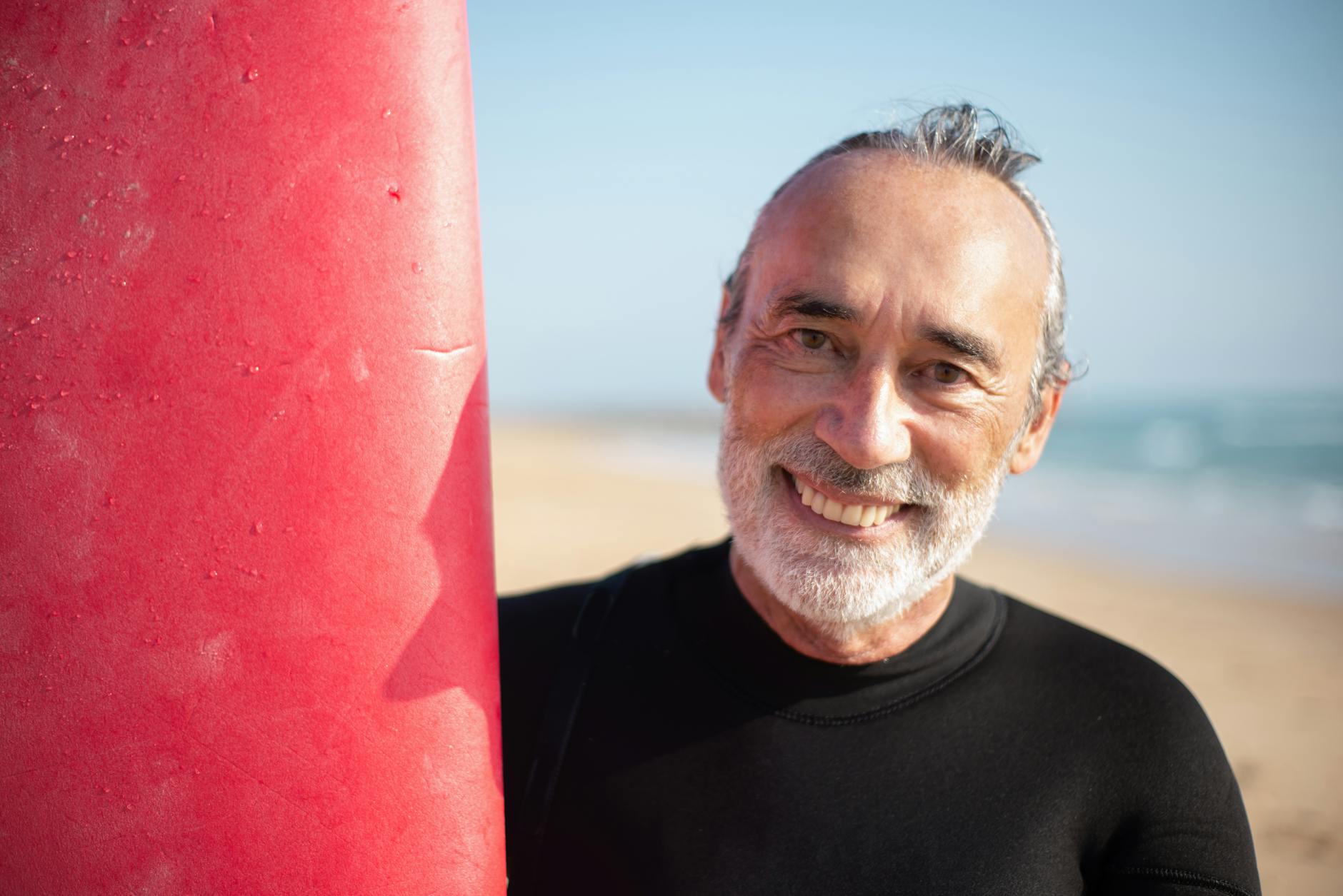 an elderly man in black shirt smiling